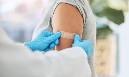 Covid virus vaccination, vaccine and doctor hands with plaster on patient arm in a medical hospital or clinic. Healthcare worker help, trust and safety flu shot antigen for protection against disease.